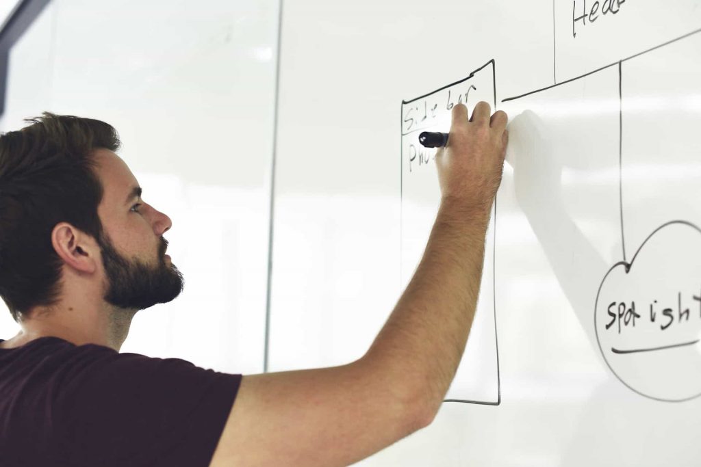 man writing on a whiteboard