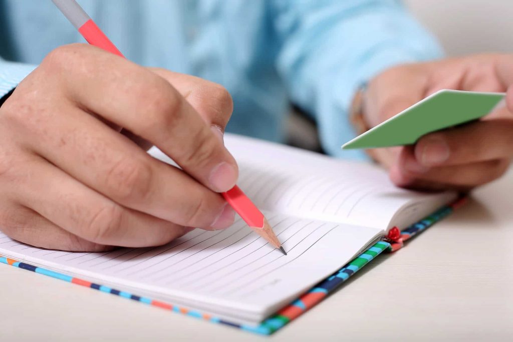 man writing on a notebook