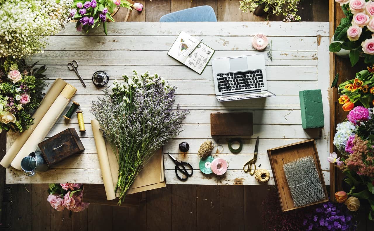 laptop flowers and pencils on a table